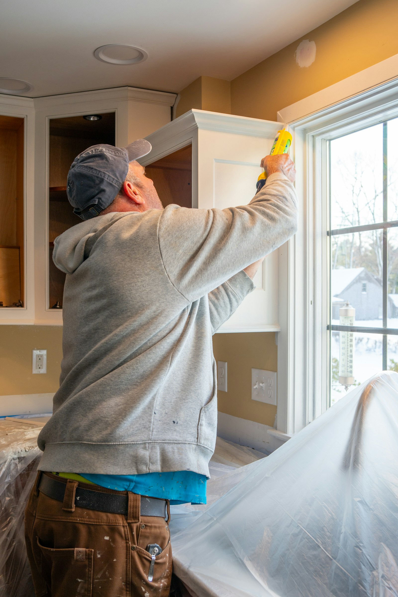 Painter working near a window inside a home